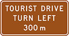 brown sign with white text, tourist drive turn left 300m