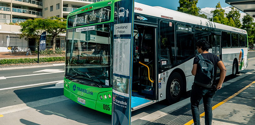 A man is entering a bus at a bus stop